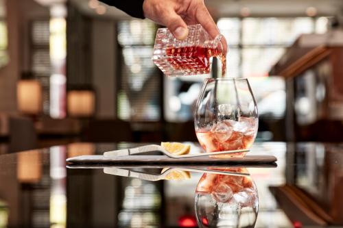 a person pouring wine into a wine glass at Antigon Urban Chic Hotel, Thessaloniki in Thessaloniki