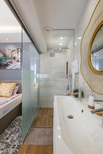 a bathroom with a tub and a bed and a mirror at Parliament Sofia - Top Center Luxury Apartment in Sofia