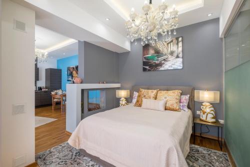 a bedroom with a bed and a chandelier at Parliament Sofia - Top Center Luxury Apartment in Sofia