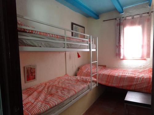 two bunk beds in a room with a window at Casa El Dragonet in Perelló