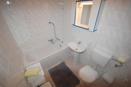 a bathroom with a sink and a tub and a toilet at Apartments Daidzic in Njivice