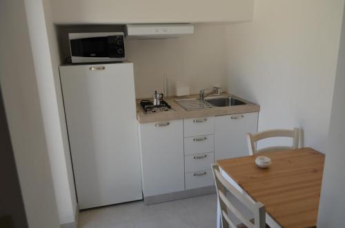 a small kitchen with a refrigerator and a microwave at Marinelli Guest House in Cisternino