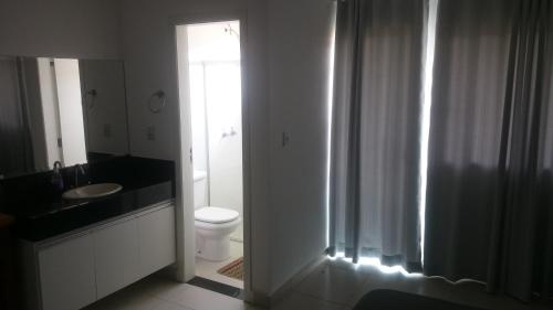 a bathroom with a toilet and a sink and a shower at Escarpas, Capitólio, Bloco 13 casas in Capitólio