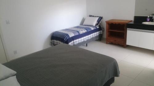 a room with two twin beds and a sink at Apartamentos Mirante de Escarpas in Capitólio