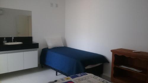 a small room with a bed and a sink at Apartamentos Mirante de Escarpas in Capitólio