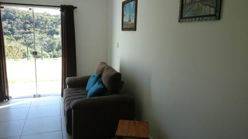 a living room with a couch and a window at Escarpas, Capitólio, Bloco 13 casas in Capitólio