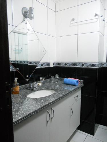 a bathroom with a sink and a mirror at Hospedagem Three Little Birds in Curitiba