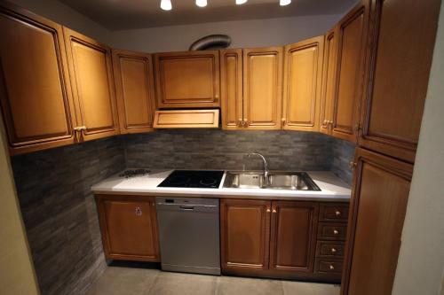 a kitchen with wooden cabinets and a sink at Champoluc Apartment in Champoluc