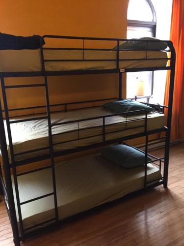 two bunk beds in a room with a window at Auberge Alternative in Montréal