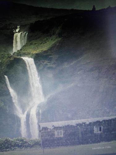 a painting of a waterfall with a building next to it at Casa vicente in Santa Cruz das Flores