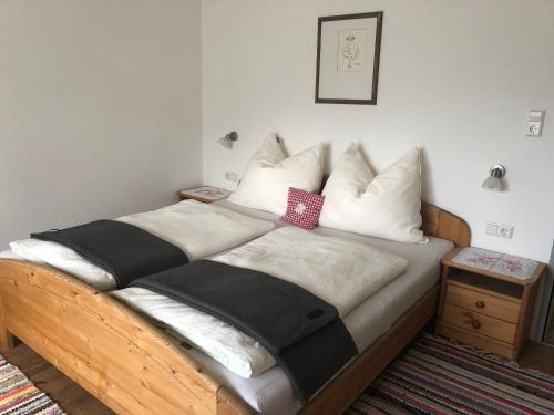 a bed with white and black sheets and pillows at Sonnseitn Klaunz27 in Matrei in Osttirol