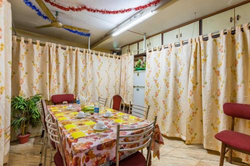 comedor con mesa, sillas y cortinas en Sonnetta Residency, en Kochi