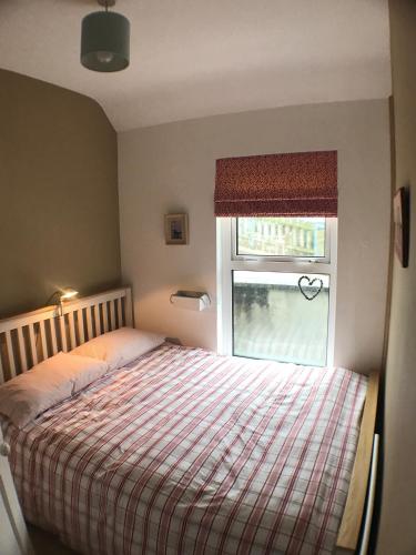 a bedroom with a bed and a window at Ridge Cottage Portrush in Portrush