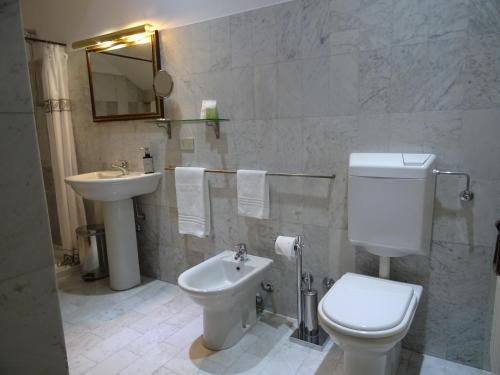 a bathroom with a white toilet and a sink at CharmeRooms Villa Moroni in Stezzano