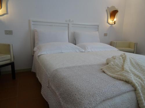 a bedroom with a white bed with a blanket on it at CharmeRooms Villa Moroni in Stezzano