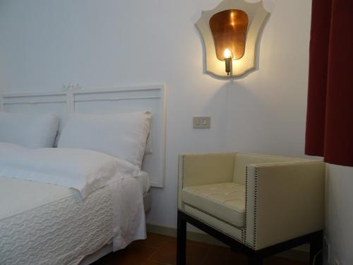 a bedroom with a bed and a chair and a light at CharmeRooms Villa Moroni in Stezzano