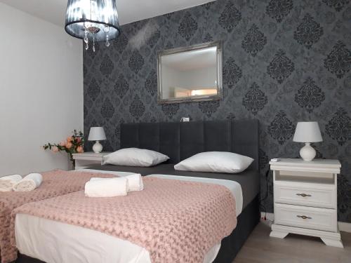 a bedroom with two beds and a mirror on the wall at Apartman Sanja in Ploče