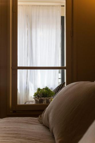 a bedroom with a window with a potted plant at Maison Volver in Arles