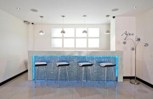 a bar with blue stools in a room at Hotel Kilton in San Carlos de Bariloche
