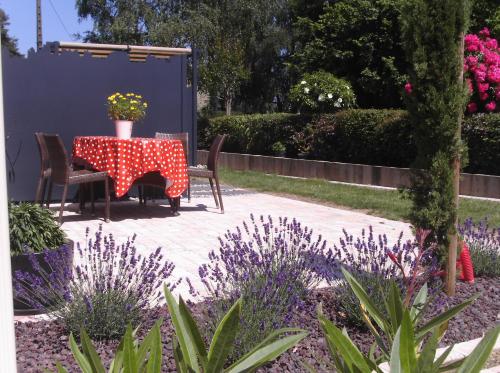 MouchampsにあるGîte le logisの花の咲く庭園のテーブルと椅子