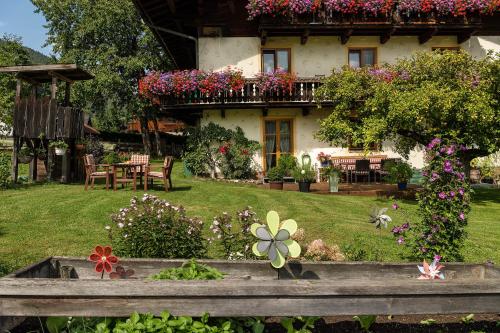 a house with a bunch of flowers in the yard at Haus Knapp FeWo Gastein in Dorfgastein