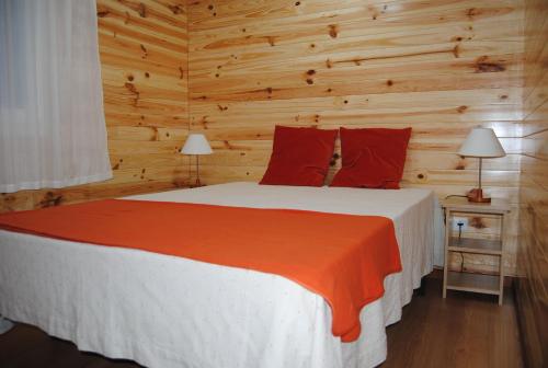 a bedroom with a large bed with wooden walls at Quintinha Santar in Santar