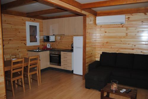 a living room with a couch and a kitchen at Quintinha Santar in Santar