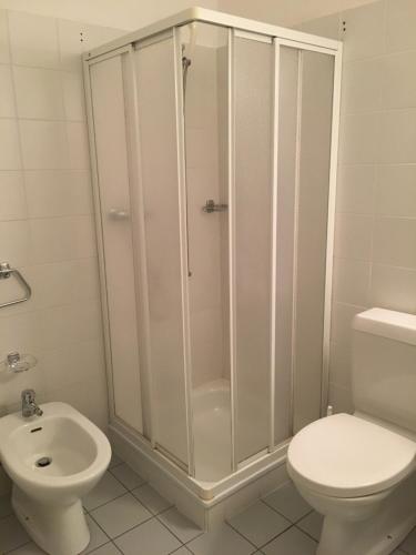 a bathroom with a shower and a toilet and a sink at Hotel San Giobbe in Giubiasco