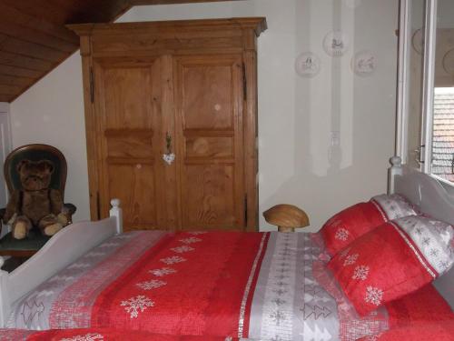 a bedroom with a bed with a red blanket at Le Chant du Coq in Bief-des-Maisons