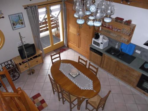 una cucina e una sala da pranzo con tavolo e sedie di Le Chant du Coq a Bief-des-Maisons