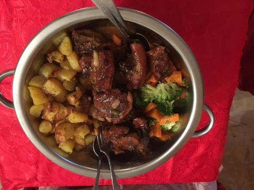 a pot of stew with meat and vegetables on a red table at Hotel San Giobbe in Giubiasco