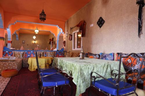 a room with a table and chairs and a couch at Kasbah Du Berger & Piscine in Merzouga