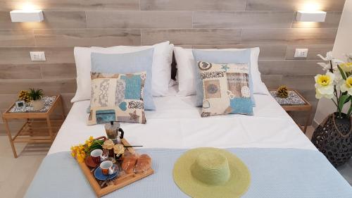 łóżko z tacą z jedzeniem i kapeluszem w obiekcie Martin Holiday Apartments w mieście Giardini Naxos