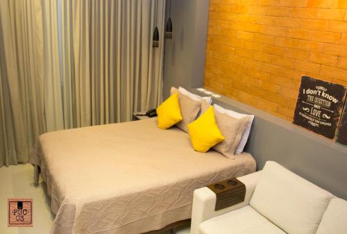een kleine slaapkamer met een bed met gele kussens bij PUC 03 Itaipava RJ in Itaipava