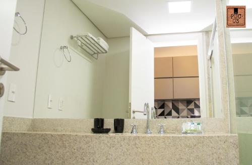 a bathroom with a sink and a mirror at PUC 03 Itaipava RJ in Itaipava