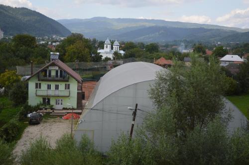 a large white dome building in front of a house at Baza Sportiva Adelina in Cîmpulung