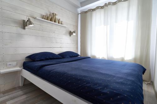 - une chambre avec un lit doté de draps bleus et une fenêtre dans l'établissement Современная 2-комн. Дворец Украина., à Kiev