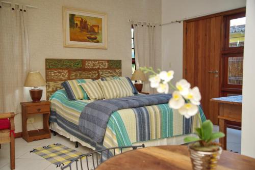 1 dormitorio con 1 cama y 1 mesa en Pousada Banzay, en Paraty