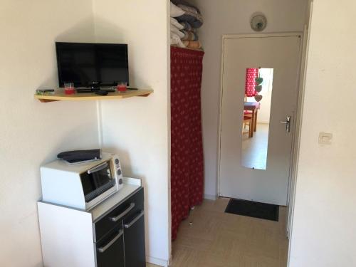 a living room with a microwave on a counter and a hallway at Bois d'Aurouze SuperDévoluy in Les Cypières