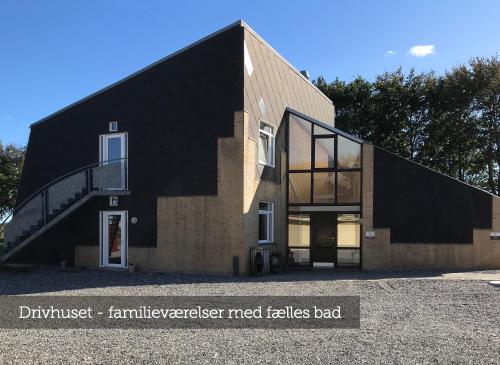 a house with a black roof and a staircase at Oasen Samsø in Nordby