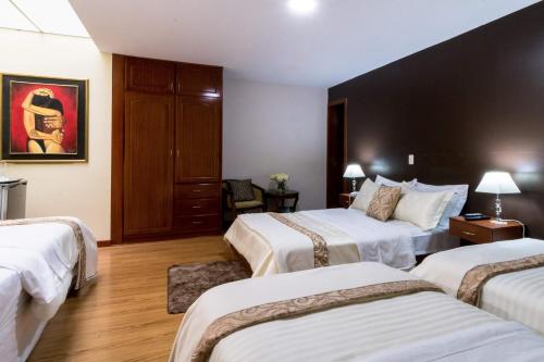 a hotel room with two beds with white sheets at Hotel Boutique Castilla de Leòn in Cuenca
