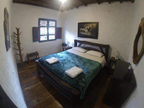 a bedroom with a bed with two towels on it at Finca Campestre La Adelita B&B in Salento