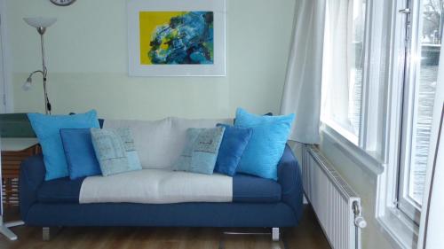 a blue couch with blue pillows in a living room at Houseboat In The Center, 5 min walk to Tropical Museum, Free Wifi! in Amsterdam