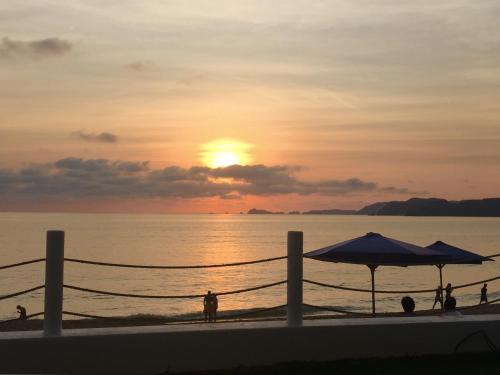 a sunset on the beach with people on the beach at Hotel Barra de Navidad in Barra de Navidad