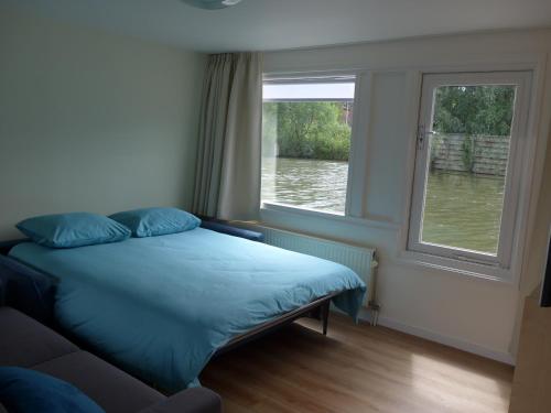 a bedroom with a bed and a window with water at Houseboat In The Center, 5 min walk to Tropical Museum, Free Wifi! in Amsterdam