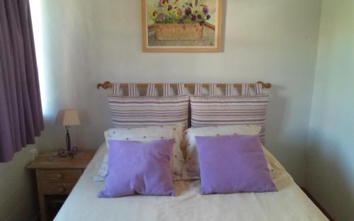 a bedroom with a bed with purple pillows at Chalet Monachil in Monachil