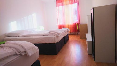 a bedroom with two beds and a window at AVI City Apartments BismarckHouse in Düsseldorf