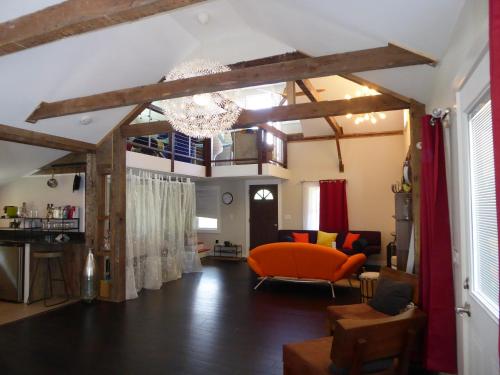 a living room with a chandelier and an orange chair at Romantic, Magical Cottage in Catskills nr Woodstock in Willow