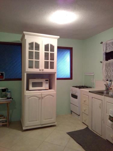 a kitchen with white cabinets and a microwave at LeMarida Suites in Saint Peter