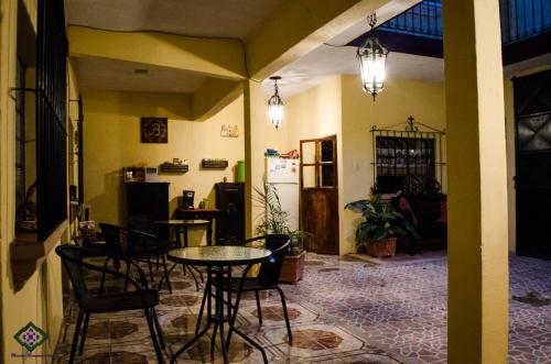 a room with a table and chairs and a refrigerator at Maison Bougainvillea in Antigua Guatemala